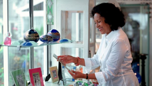 Smiling lady looking at pictures in a gift shop